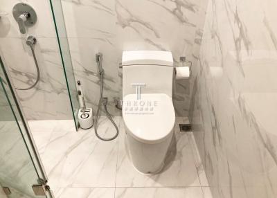 Modern bathroom with marble tiles and a white ceramic toilet