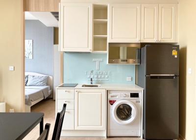 Modern kitchen with integrated appliances adjacent to a bedroom area