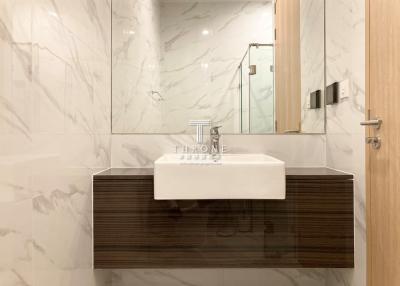 Modern bathroom interior with marble walls and wooden vanity