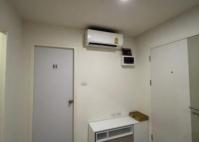 Compact bedroom with air conditioning unit and wooden flooring