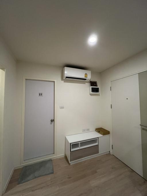 Compact bedroom with air conditioning unit and wooden flooring