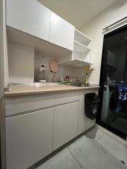 Modern compact kitchen with white cabinetry and stainless steel appliances