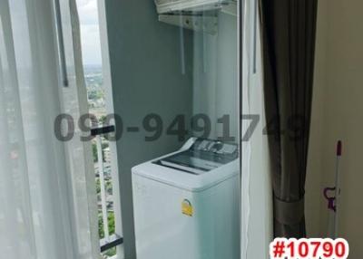 Compact home laundry area with a washing machine and a clear view outside.