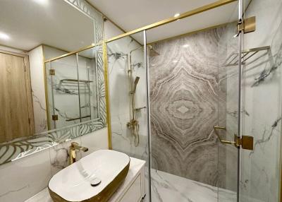 Modern bathroom interior with marble finishes and gold accents