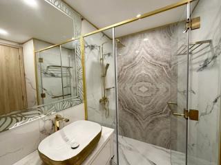 Modern bathroom interior with marble finishes and gold accents