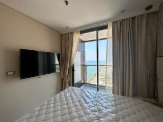 Modern bedroom with a large window overlooking the sea