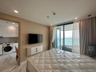 Studio apartment interior with kitchenette, bed, and sea view