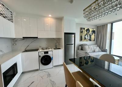 Modern open-concept kitchen with adjacent living room featuring stylish decor and natural light