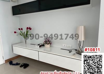 Minimalist living room interior with modern white console, decorative lamp, and flowers