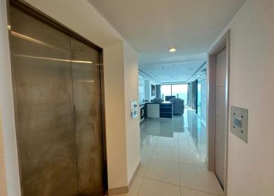 Modern corridor with shiny floor tiles leading towards an open-concept kitchen