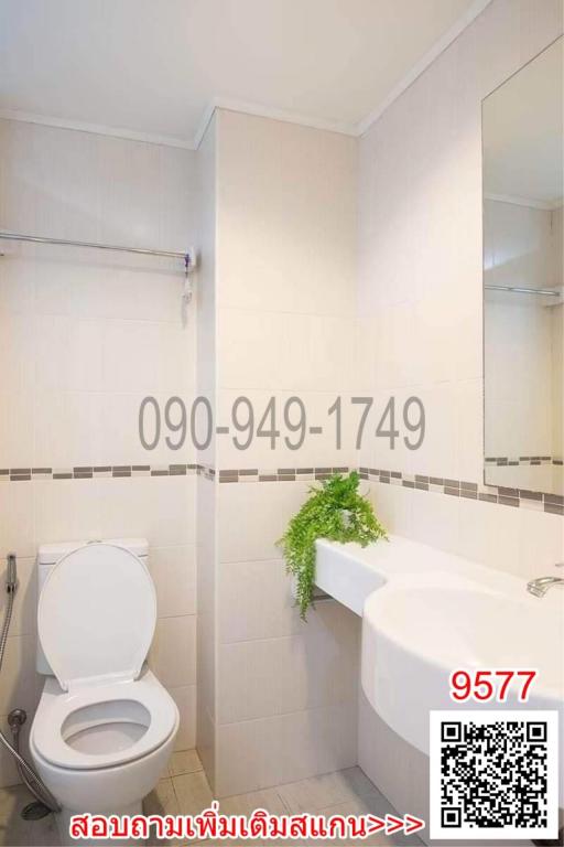 White Tiled Bathroom with Toilet and Bathtub