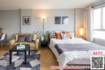 Studio apartment bedroom with integrated living space, natural light, and modern decor