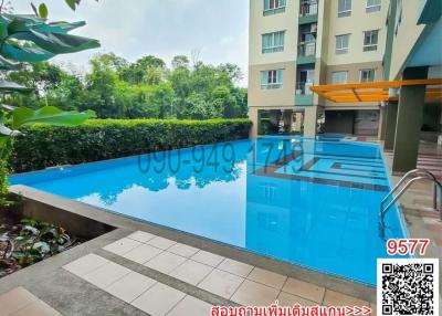 Swimming pool by a residential building surrounded by lush greenery