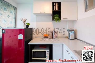 Modern kitchen with red refrigerator and white cabinetry