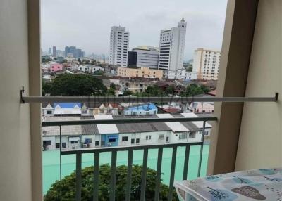 City view from a high-rise balcony with a safety railing