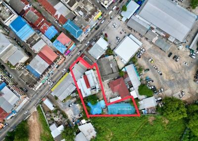 Aerial view of a property with outlined boundaries amidst an urban setting