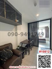 Modern living and dining area with sofa, dining table, and access to bedroom