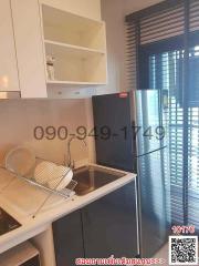 Modern compact kitchen with stainless steel sink, white cabinets, and red refrigerator