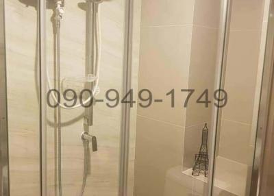 Modern glass shower stall with wall-mounted shower fixtures in a clean bathroom