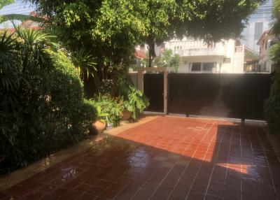 Spacious and lush garden area with tiled walkway and secure gate