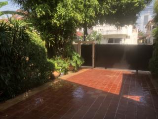 Spacious and lush garden area with tiled walkway and secure gate