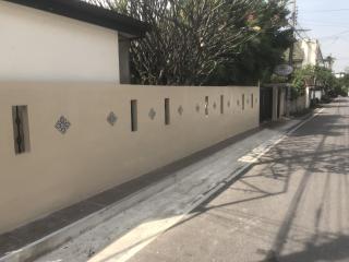 Residential street view with decorative wall and gated entry