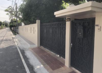 Secure gated entryway to a residential property with a surrounding wall