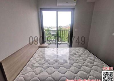 Spacious bedroom with large bed and natural light from balcony doors