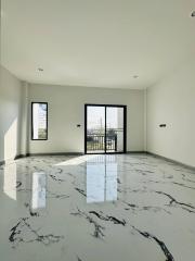 Spacious and bright unfurnished living room with large windows and marble flooring