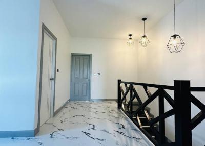 Modern hallway with marble flooring and unique pendant lights