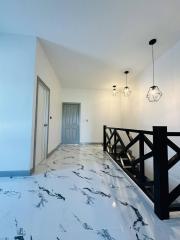 Modern hallway with marble flooring and unique pendant lights