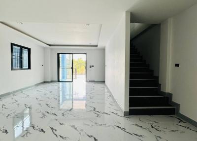 Spacious unfurnished interior of a modern house with marble floors and a staircase