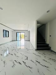 Spacious unfurnished interior of a modern house with marble floors and a staircase