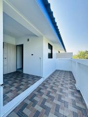 Spacious balcony with patterned floor and clear sky