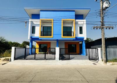 Bright blue two-story house with balcony and secure gate