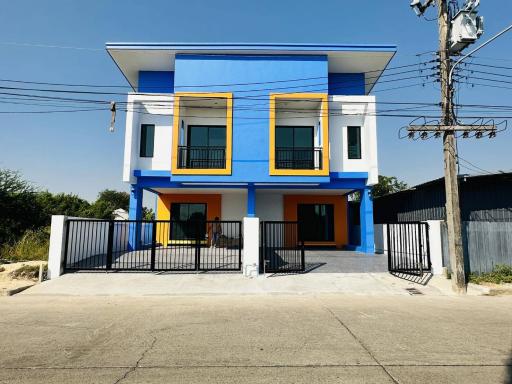 Bright blue two-story house with balcony and secure gate