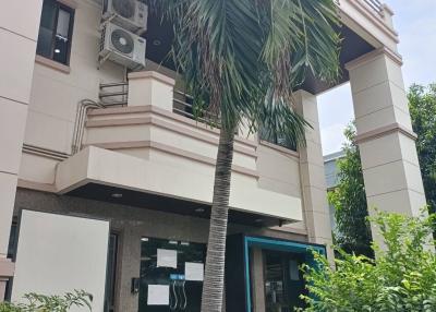 Exterior view of a modern residential building with a palm tree