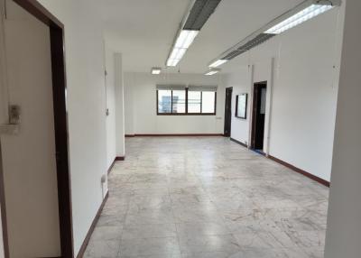 Spacious empty interior of a building with large windows and tiled flooring