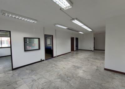 Spacious open plan commercial space with large windows and tiled flooring