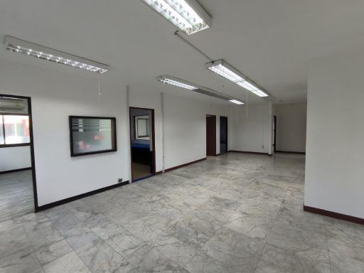 Spacious open plan commercial space with large windows and tiled flooring