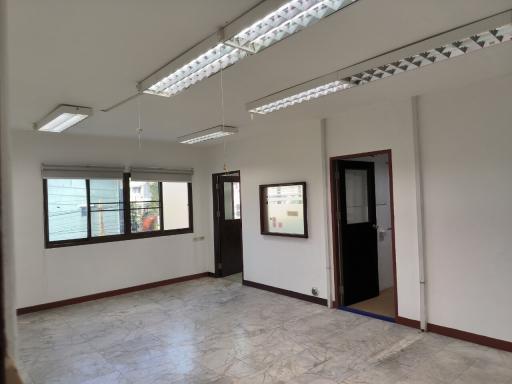 Spacious empty room with large windows and tiled flooring