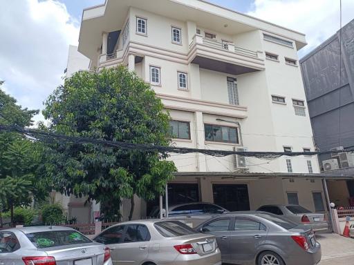 Exterior view of a multi-story residential building with parking space