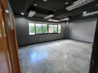 Spacious unfurnished interior of a modern building with large windows and marble flooring