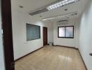 Spacious empty room with tiled floor, large windows, and recessed lighting