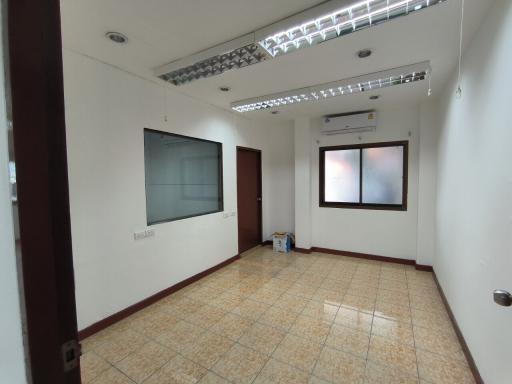 Spacious empty room with tiled floor, large windows, and recessed lighting