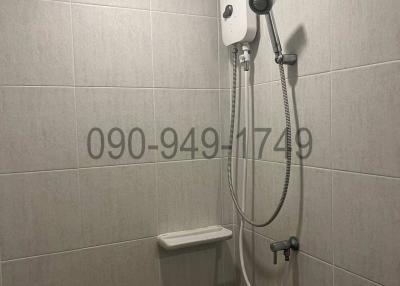 Compact bathroom with wall-mounted shower and water heater