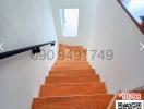 Wooden stairway with natural light coming from the window above