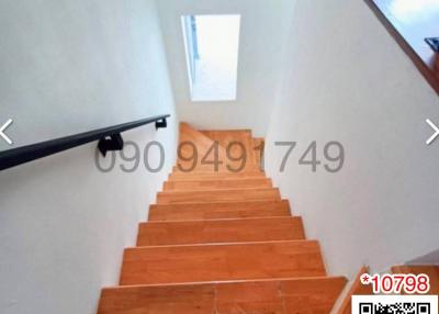 Wooden stairway with natural light coming from the window above
