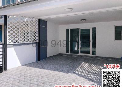 Spacious outdoor patio area with tiled flooring and privacy wall