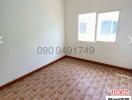 Spacious empty bedroom with two windows and tiled floor